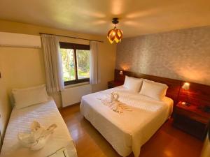 a bedroom with two beds with towels on them at Pousada Pinhão e Poesia in Canela