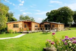 a log cabin in a yard with flowers at 6 Bed in Alkham oc-p34791 in Swingfield