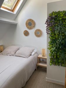 a bedroom with a bed and two mirrors on the wall at Lapacy Hardelot in Neufchâtel-Hardelot
