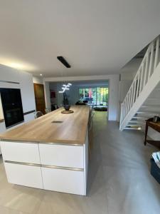 a kitchen with a white island with a wooden counter top at Lapacy Hardelot in Neufchâtel-Hardelot