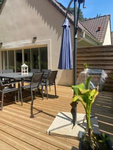 a wooden deck with a table and an umbrella at Lapacy Hardelot in Neufchâtel-Hardelot