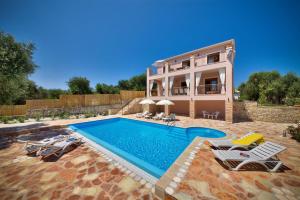 a villa with a swimming pool in front of a house at Villa Androniki in Longós