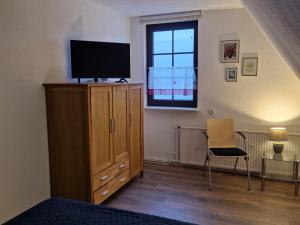 a bedroom with a tv on top of a dresser at Lange Str. 15 - Ferienwohnung in Prerow