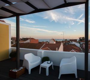 a balcony with two chairs and a view of the ocean at Day Off Suite&Hostel in Setúbal