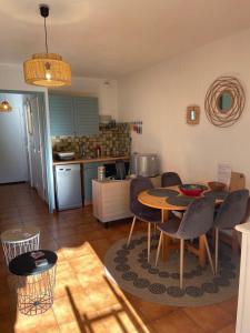 a kitchen and dining room with a table and chairs at studio cabine. Terrasse in Le Lavandou +13 photos