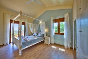 a bedroom with a canopy bed and a window at Villa Androniki in Longós