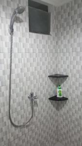 una ducha en un baño de azulejos con cabezal de ducha en Papilukas Room Kalibata City - Studio Silver, en Yakarta 24 fotos más