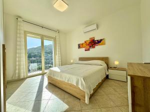 a bedroom with a bed and a large window at Skyline Balcony in Loceri