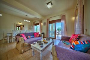 a living room with two couches and a table at Villa Androniki in Longós