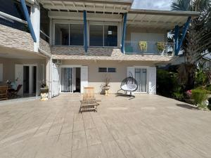 a patio with two chairs and a house at Bas de Villa Tropical Soul in Pointe-Noire