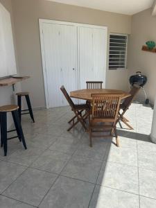 a wooden table and chairs in a room at Bas de Villa Tropical Soul in Pointe-Noire