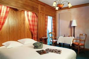 a hotel room with a bed and a table with a table at Hôtel A la Vignette - COLMAR-NORD in Saint-Hippolyte