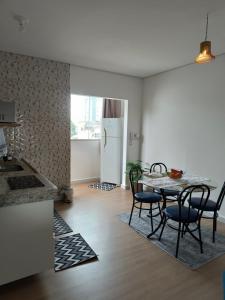a kitchen and dining room with a table and chairs at Flat Equipado no Centro - Conforto in Governador Valadares