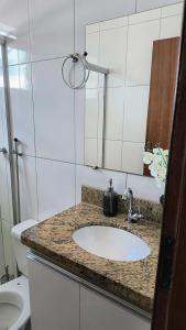 a bathroom with a sink and a mirror at Flat Equipado no Centro - Conforto in Governador Valadares +7 photos
