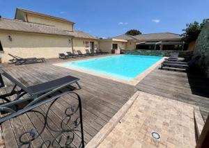 a swimming pool with chaises and chairs next to a house at I Bugni in Sisco