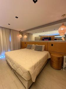 a bedroom with a large bed and a large mirror at Pousada Alpes Azul in Campos do Jordão