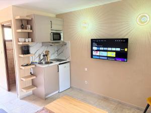 a kitchen with a refrigerator and a tv on the wall at I Bugni in Sisco