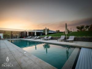 a swimming pool with chairs and a building at Pacheca The Wine House Hotel e Spa - Quinta da Pacheca in Lamego