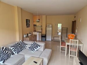 a living room with a white couch and a kitchen at Harmony Hills Family Apartments in Rogachevo