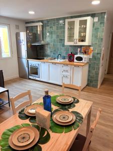 a kitchen with a wooden table with plates on it at Soñar en la Plaza Cervantes 2 in Alcalá de Henares