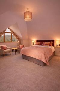 a bedroom with a large bed and a chair at Derrynane Bay House in Caherdaniel +29 photos
