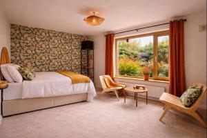 a bedroom with a bed and a window and a chair at Derrynane Bay House in Caherdaniel