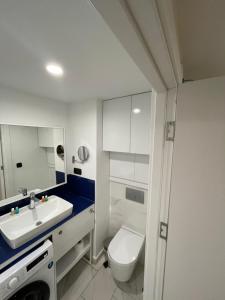 a bathroom with a white toilet and a sink at Orbi HighView Panoram Hotel in Batumi +163 photos
