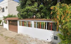 a white wall with a fence in front of a house at Casa da Vovó Ivete in Guarapari