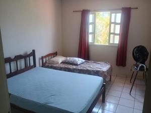 a bedroom with two beds and a window at Casa da Vovó Ivete in Guarapari