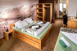 a bedroom with two beds and a wall with mountains at Vila Emma in Štrbské Pleso