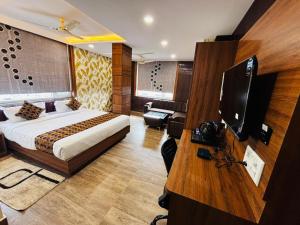 a bedroom with a bed and a television in a room at Hotel Downtown in Jamshedpur