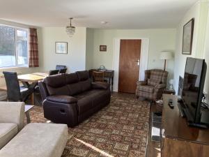 a living room with a couch and a table at Crianlarich Cottage in Fort Augustus