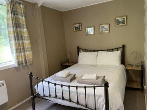 a bedroom with a bed with two towels on it at Crianlarich Cottage in Fort Augustus