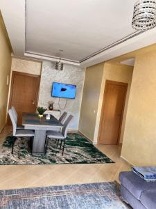 a dining room with a table and chairs and a tv at Apartmen rentals with M Z in Marrakesh