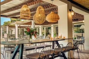 a patio with a table and chairs and lights at Zeus Dolce by Wyndham Athens in Vravrona