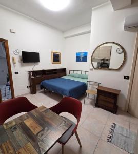a bedroom with a bed and a table and a mirror at Monolocale Agesidamo in Locri