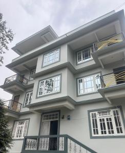 a large white building with windows and a balcony at The Golden Attic in Yangang