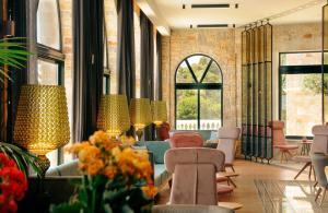 a lobby with chairs and tables and windows at Zeus Dolce by Wyndham Athens in Vravrona