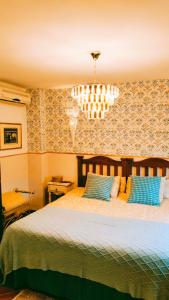 a bedroom with a large bed with blue pillows at Todos Y Tonya in Archidona
