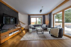 a living room with a couch and a tv at Chalet Zillertal Arena 1 in Kirchdorf