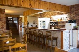 a restaurant with a bar with chairs and a refrigerator at Scone Motor Inn & Apartments in Scone