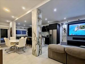 a living room with a table and a large screen tv at Modern House with Pool - 10 Guests Max in Taʼ Ċantar