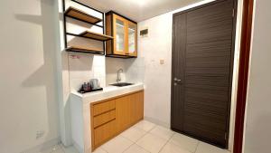 a small kitchen with a sink and a door at Escotel Amazana in Cileduk 1