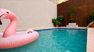 a pink inflatable flamingo in a swimming pool at Modern House with Pool - 10 Guests Max in Taʼ Ċantar