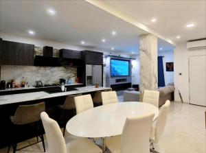 a kitchen and living room with a white table and chairs at Modern House with Pool - 10 Guests Max in Taʼ Ċantar