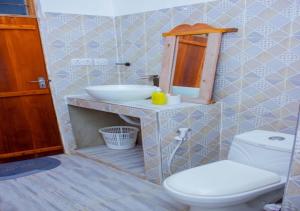 a bathroom with a white toilet and a sink at Datch Hideaway in Kiwengwa +68 photos