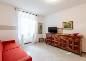a living room with a red couch and a television at Casa di Montagna tranquilla e spaziosa in Serina