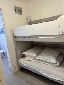 a bunk bed with two pillows on top of it at Topette Les Mouettes in Quiberon +13 photos