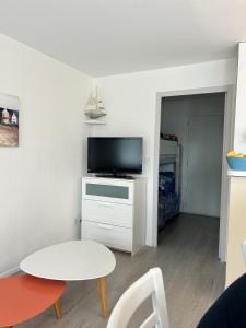 a living room with a tv and a table at Topette Les Mouettes in Quiberon