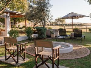 a group of chairs and an umbrella in a yard at OLYF accommodation in Bloemfontein